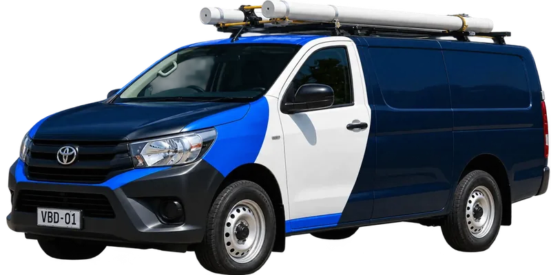 A licensed Ashfield plumbing van loaded with pipe on the roof rack